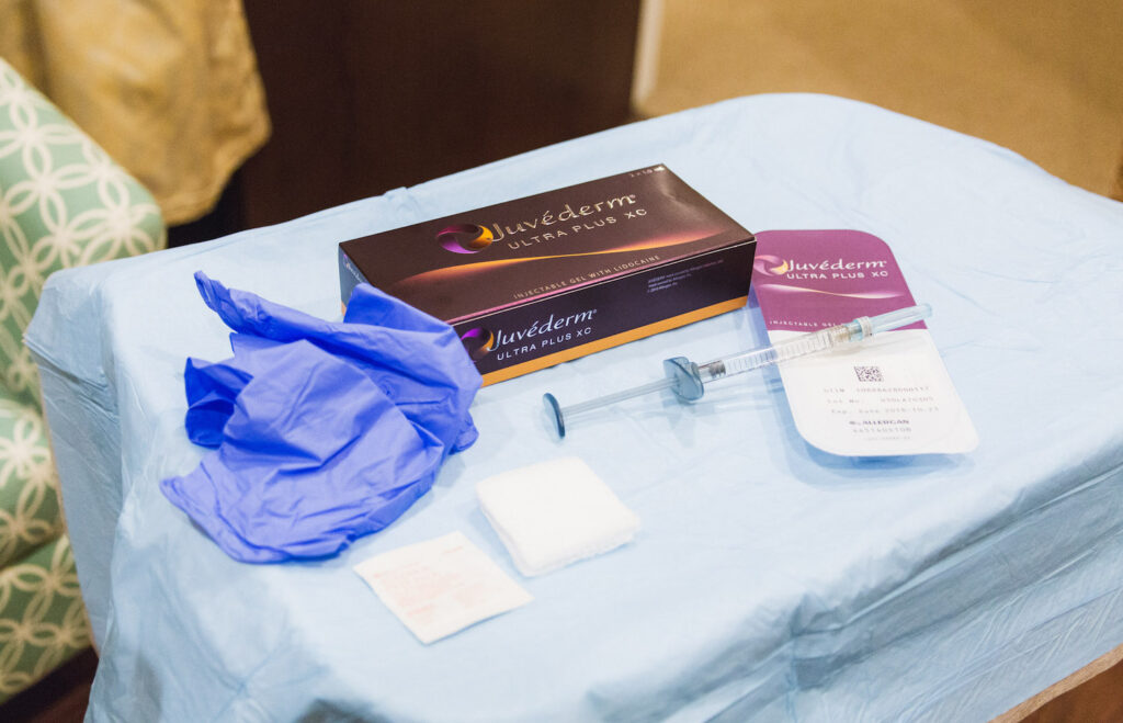 A syringe laying neatly on top of the packaging for Juvederm dermal fillers in Mason, OH. Next to the box the provider layed out gloves and disinfectant wipes to prepare for the next appointment.