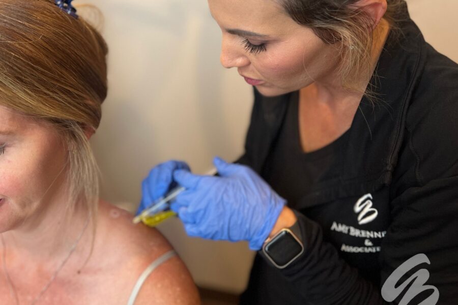 An Amy Brenner, MD & Associate's injector administering Botox for muscle tension in Cincinnati to a female patient's shoulder.