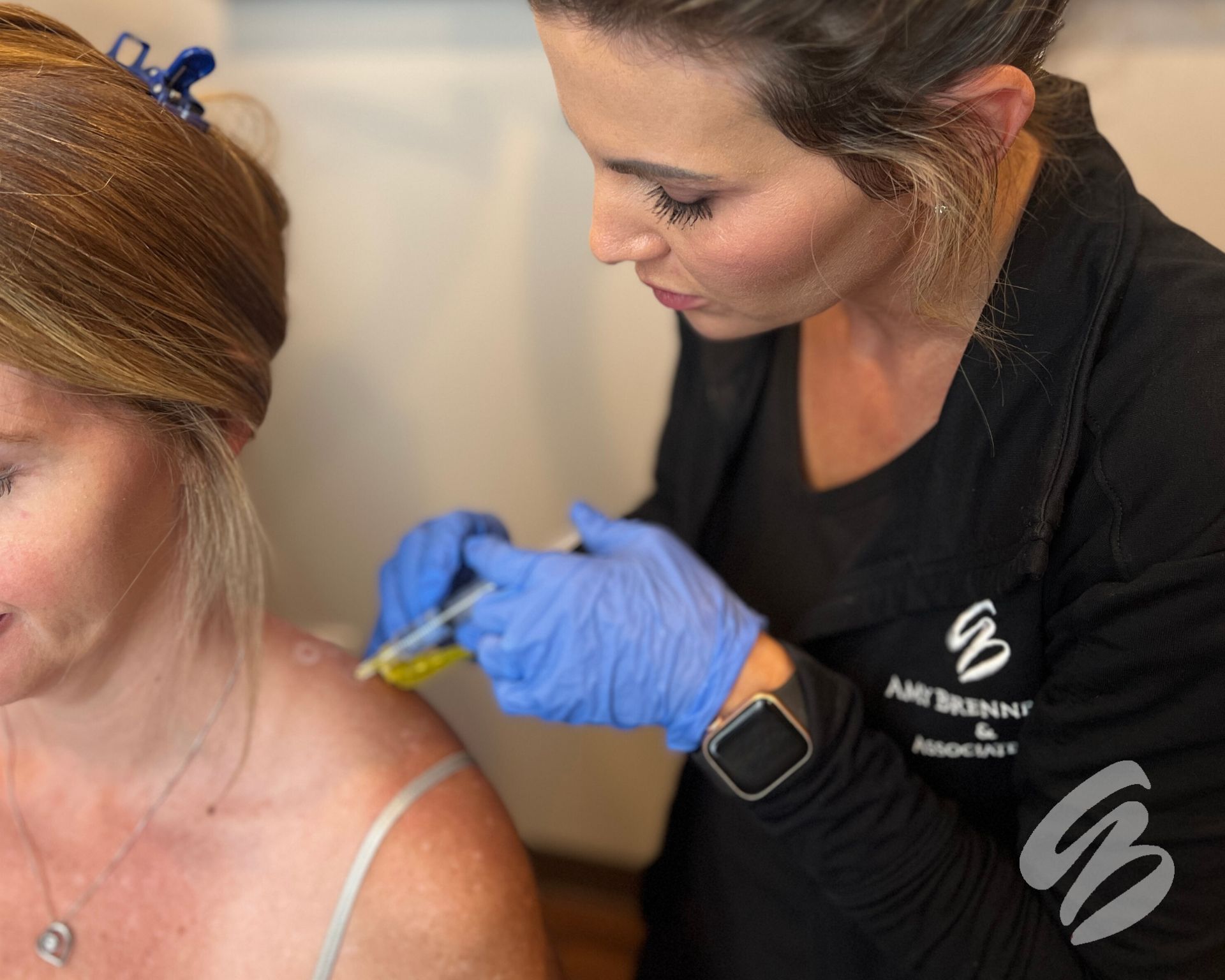 An Amy Brenner, MD & Associate's injector administering Botox for muscle tension in Cincinnati to a female patient's shoulder.