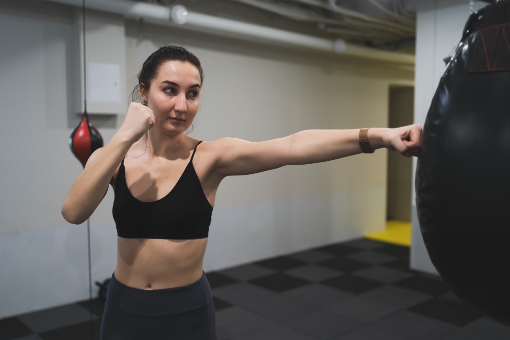 young woman exercising using punching bag