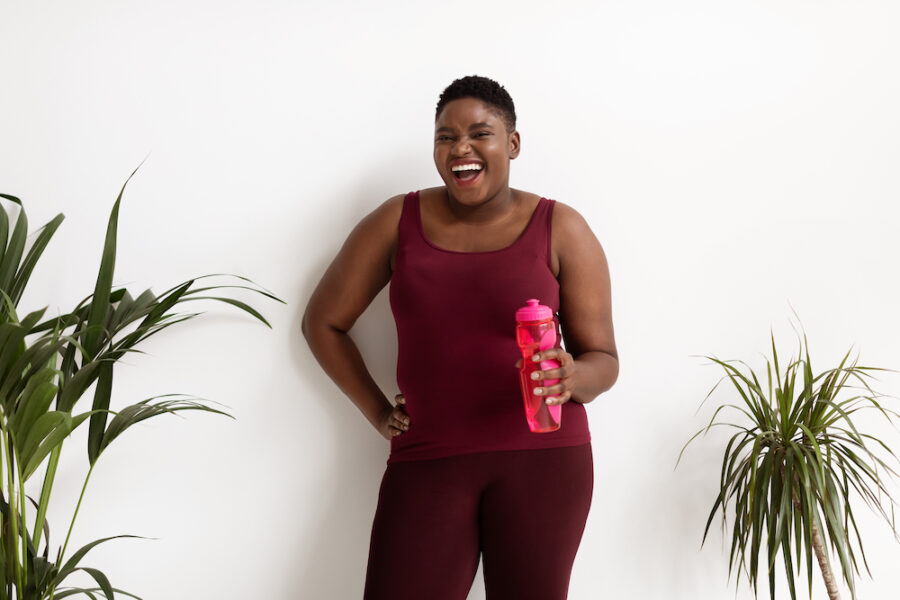 mid size woman posing in athletic wear during medical weight loss process