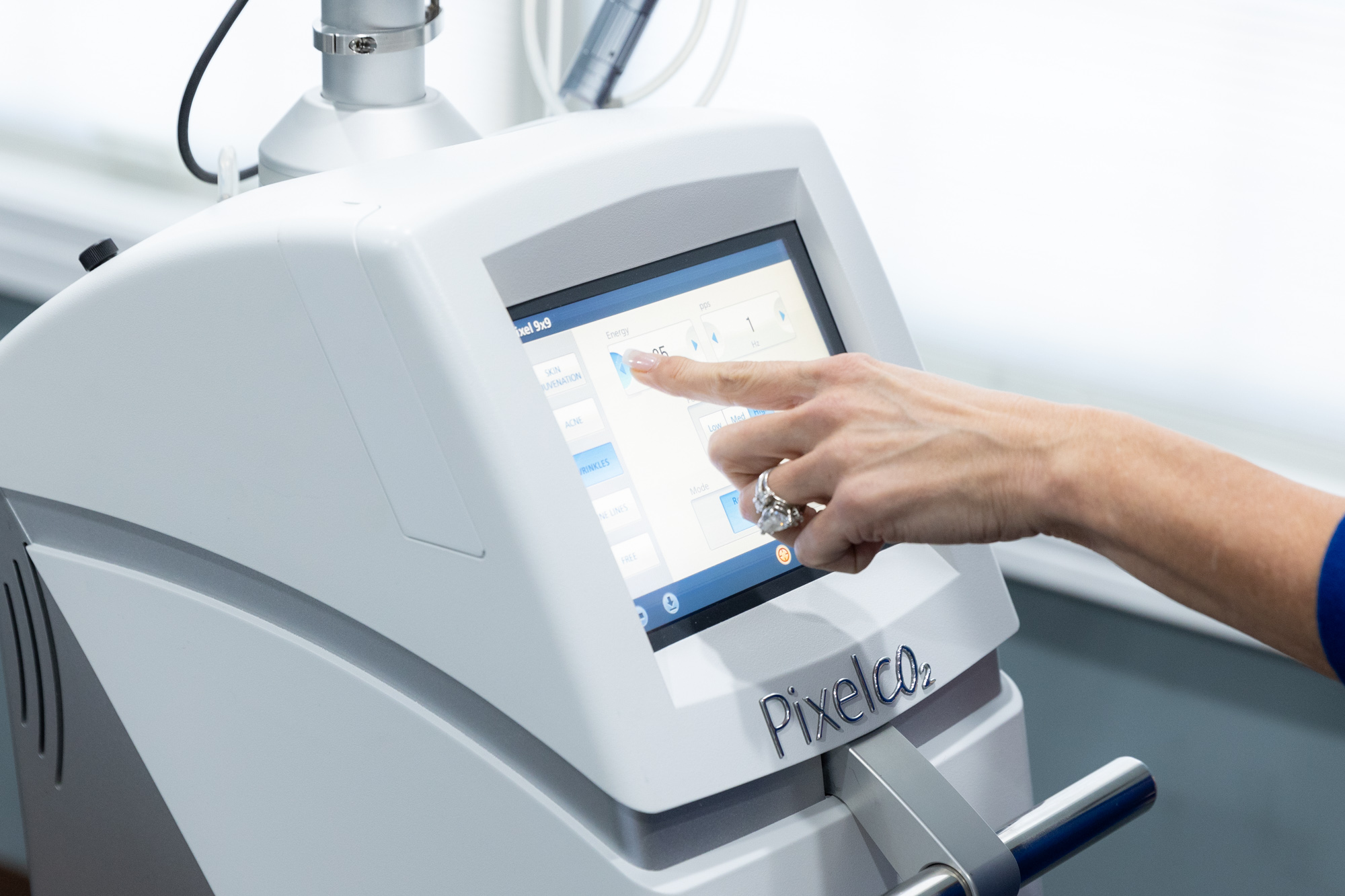 Close up of someone selecting a setting on the digital screen of a Pixel CO2 laser platform to perform spot treatment for dark spots.