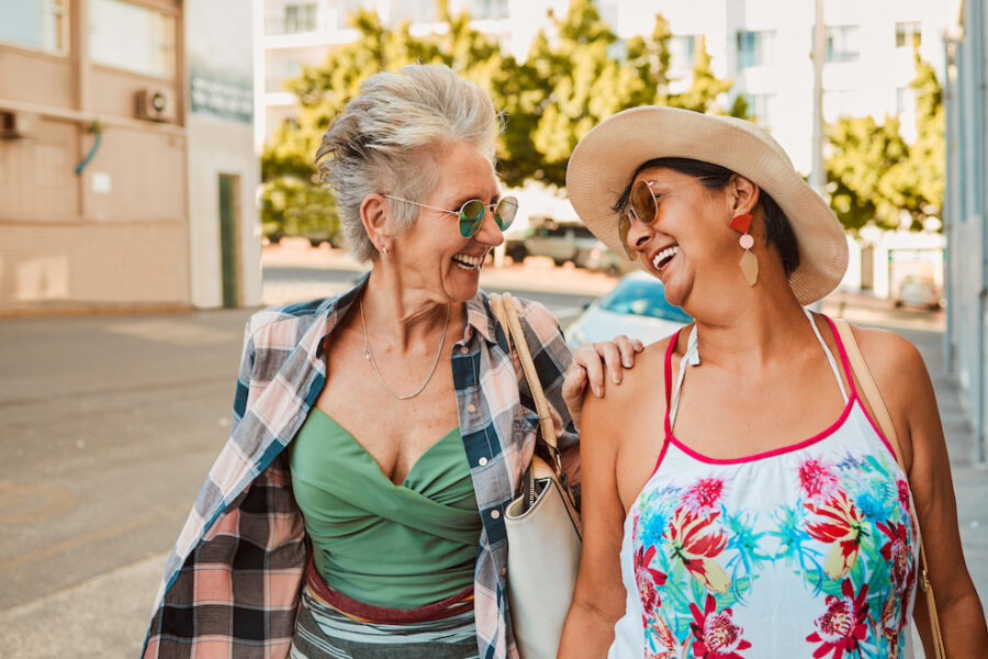 Two women walking through the city, laughing freely after their bladder leakage treatment in Cincinnati.