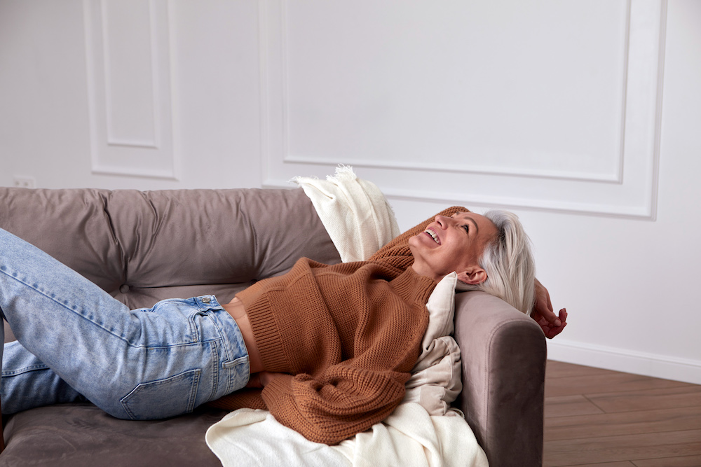 Woman laying on the couch laughing