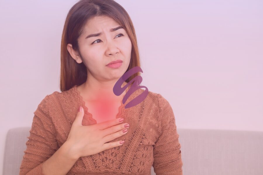 woman holding chest experiencing acid reflux