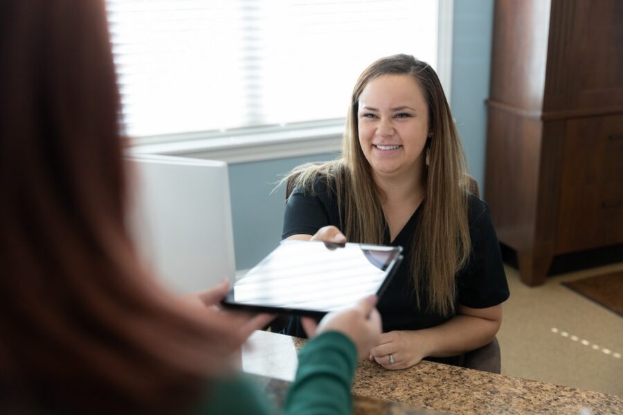 A woman passing a clipboard to a patient for weight loss medication in Cincinnati
