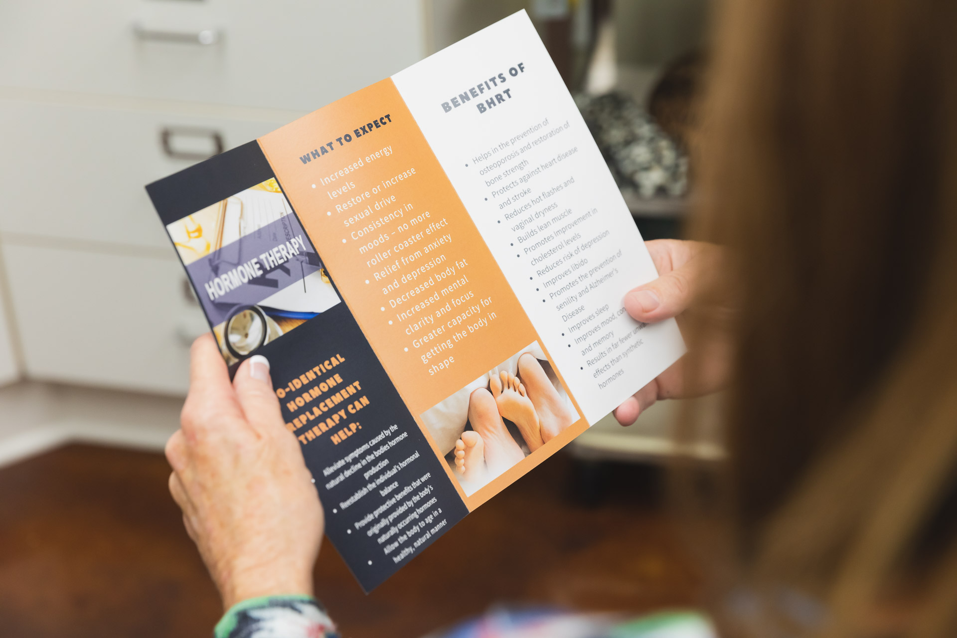Close up a person holding open a broshure about hormone replacement therapy in Cincinnati