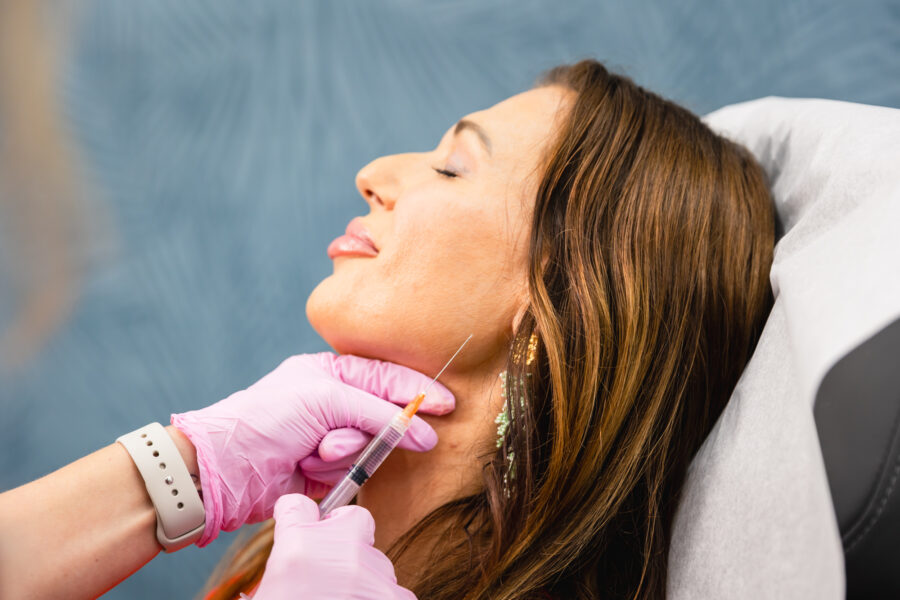 A woman getting facial rejuvenation in Cincinnati at Amy Brenner, MD & Associates via Sculptra injections in her jawline.