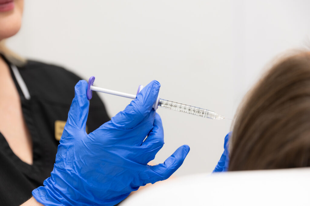 Close up of gloved hands injecting lip filler in Cincinnati.