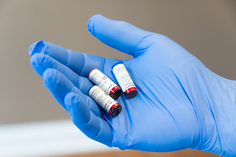 A gloved hand holding 3 vials of medication for TRT in Cincinnati.